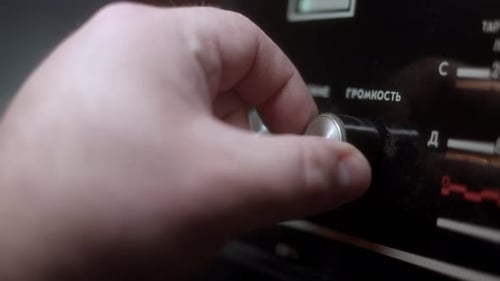 Handdrehen der Lautstärke auf einem alten Vintage-Radio, hergestellt in der UdSSR, Inschriften in russischer Sprache