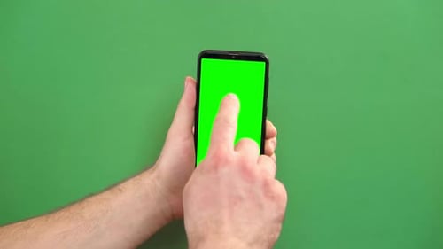 Junger Mann benutzt Smartphone mit grünem Bildschirm auf grünem Hintergrund Gesten Pack Männliche Hand berührt
