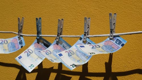 Euro Bills Hanging on a Rope on Clothespins and Flutter Money Sways in the Wind on the Background of