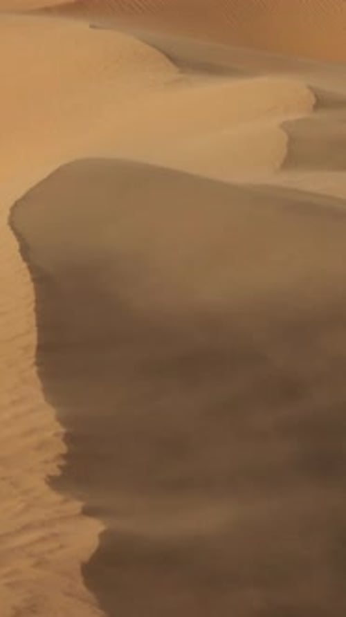 Sand Blowing Over Sand Dunes in Desert