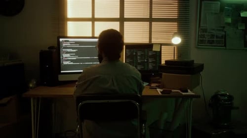 Programmer Sitting at Desk, Stretching Back After Long Coding Session at Home