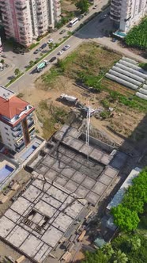 Vídeo vertical Los trabajadores colocan ladrillos y construyen paredes en una obra en construcción activa que avanza hacia