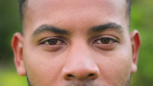 Close-up of man's face outdoors, focusing on eyes and expression