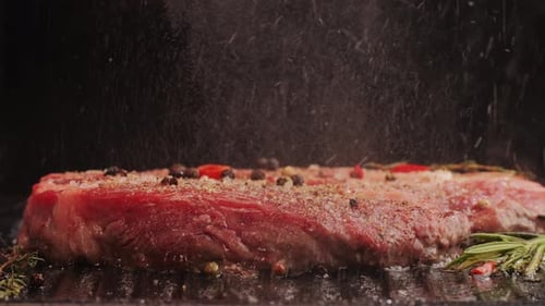 Fresh Marbled Beef with Pepper Salt and Rosemary Closeup Macro Cooking Juicy Steak on Grill with Oil