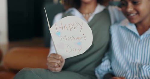 Child Hugs Mother With Handmade Mother's Day Card