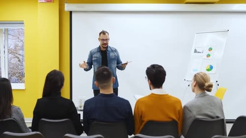 Businessman Coach Trainer Presents Report Shows Diagrams on Flip Chart in Conference Hall Project