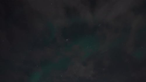 Northern Lights or Aurora Borealis Real Time Lapse with Stars and Clouds Over Icelandic Night Sky