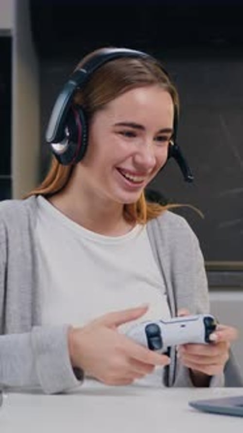 Goodlooking Excited Joyful Young Caucasian Girl in Headset Celebrating Victory in Video Game on