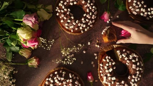 Cake and Flowers on Table with Woman's Hand