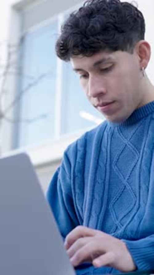 Young Adult Working on Laptop in Urban Setting