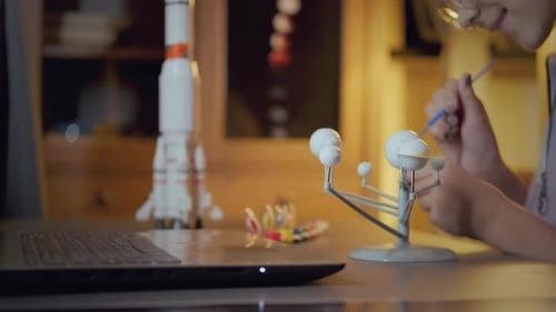 Teen Painting a Model of the Solar System