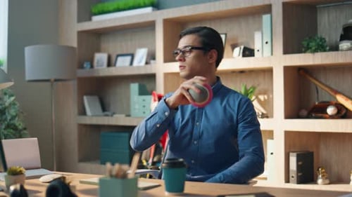 Relaxed Freelancer Tossing Ball at Office. Closeup Pensive Man Taking Work Break