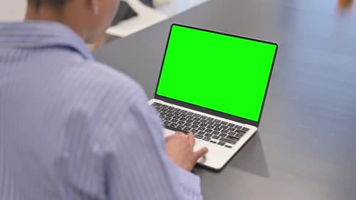 African Woman Working on Laptop with Green Screen