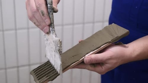 Man Applying Grout to Tile with Trowel