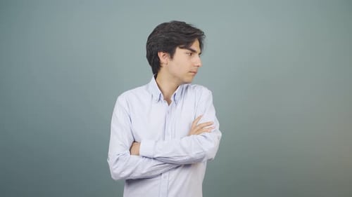 Annoyed Young Adult Crossing Arms in Studio