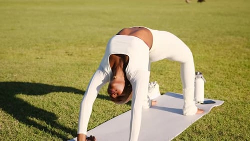 Black Woman Practicing Yoga Bridge Pose Outdoors