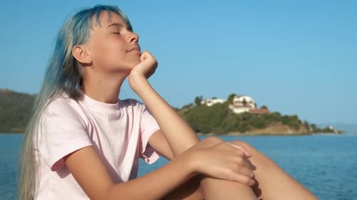 The Girl Raised Her Head Up and Enjoys the Sea Breeze