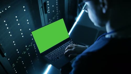 Captura de ángulo alto de un especialista en TI sosteniendo un cuaderno con pantalla verde y trabajando en él. Es un empleado