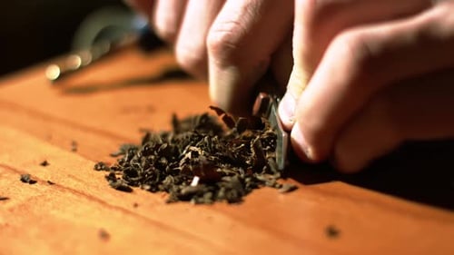 tobacco leaves tea Hands Chopping Tea Leaves on Wooden Board tobacco leaves tea Hands Chopping Tea Leaves on Wooden Board