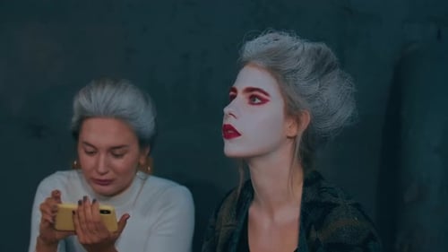 Two Women with Theatrical Makeup Looking Upward