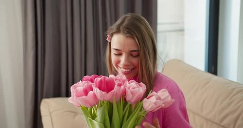 Smiling Woman Holding Bouquet of Pink Tulips