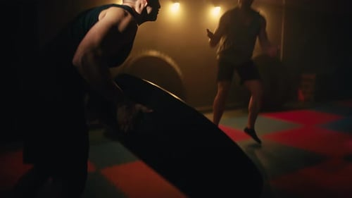Man Training to Flipping Wheel Tire Exercise Workout Into the Gym