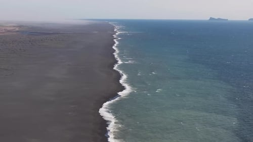 Aerial video over river dune with special colors spilling into ocean, Iceland