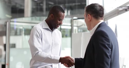 Businessmen shaking hands in a corporate office