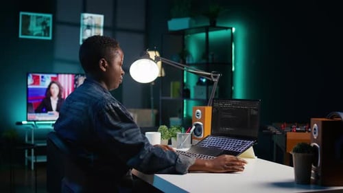 Softwareentwickler schreibt Code auf den Laptop-Bildschirm, während er im Büro einer Wohnung ist