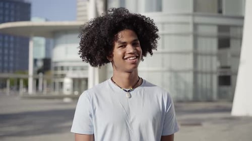 Joyeux jeune homme afro-américain regardant la caméra avec un sourire