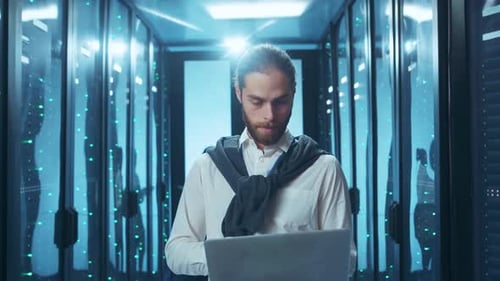 An IT Professional Engaged in Operations Within a Data Center Using a Laptop Device