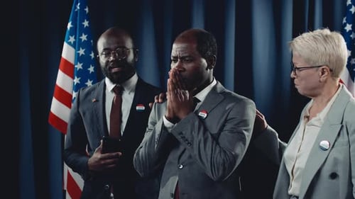 Political Figures Stand on Stage with American Flags