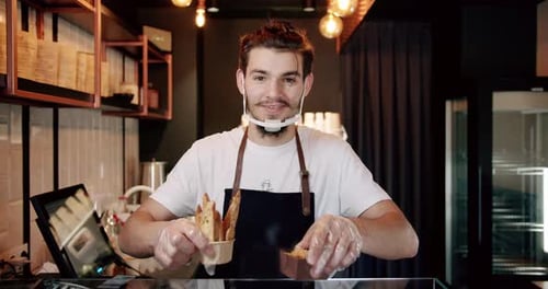 Smiling Young Adult Baker with Pastries and Face Shield
