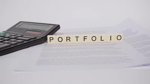Calculator and Portfolio Spelled Out on Paper