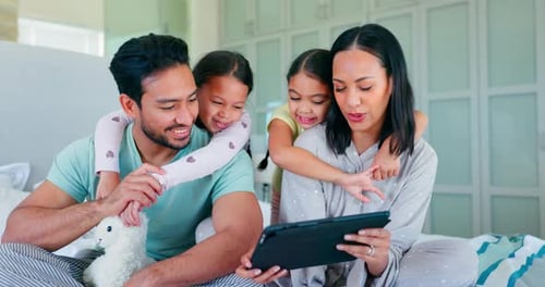Happy Family Looking at Tablet on Bed