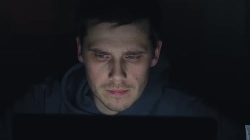 Typ, der nachts am Computer arbeitet