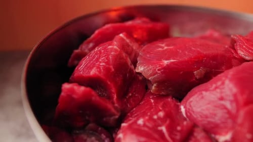 Bowl with Lumps of Fresh Raw Meat on Table in Workshop