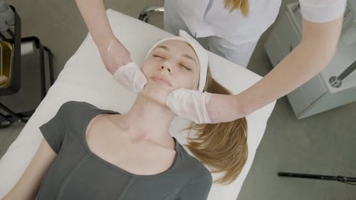 Beautician Giving Woman Facial Treatment in Spa