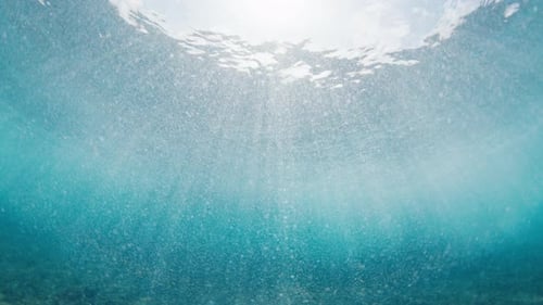 Vue sous-marine de la vague déferlante de l'océan aux Maldives. Vue sur le fond marin avec vague