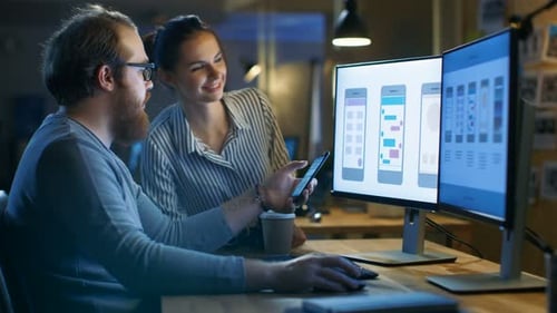 Handsome Male and Beautiful Female Mobile Application Designers Test and Discuss New App Features.