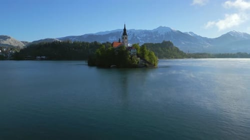 Die Bewegung des Krans über dem Kirchengebäude nach oben zeigt ein Panorama der Alpenmassive.