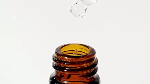 Dropper Dripping Clear Liquid Inside Amber Bottle