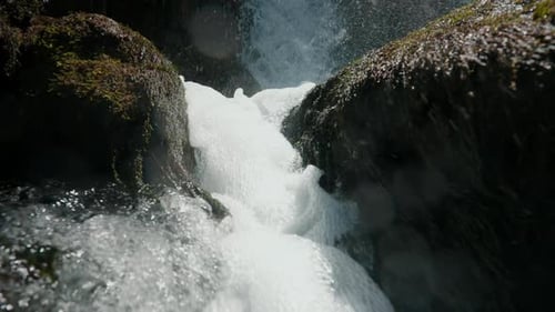 Water Flowing in Slow Motion on Mountain River Waterfall and Splashing