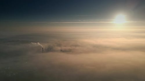Industrial Cityscape Enshrouded in Fog at Sunrise