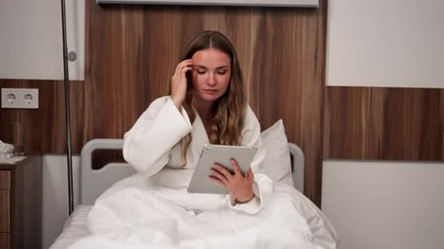 in Modern Clinic in a Bright VIP Room a Young Girl in a White Coat Lies on a Bed Before an Operation