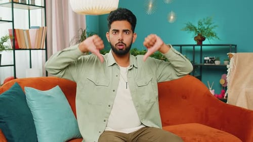 Un homme arabe bouleversé, montrant les pouces vers le bas, n'aime pas le mauvais travail, désapprobation, commentaires insatisfaits à la maison