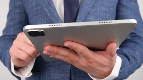 Man in Suit Using Modern Silver Tablet