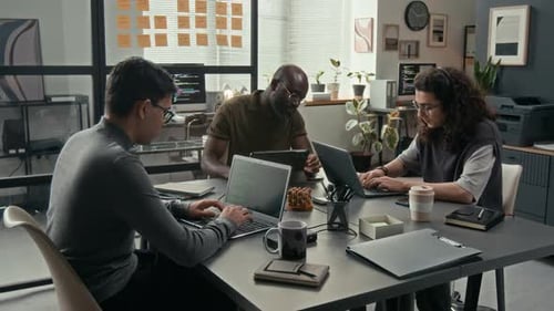 Multiethnic Team of Three Young Male Programmers Working in IT Office