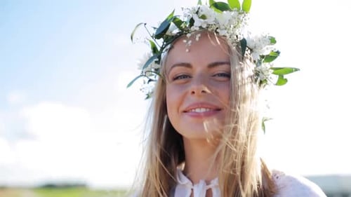 Woman in flower crown smiles in the sunshine