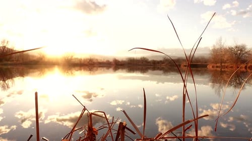 Reflection of sunset and clouds over lake surface